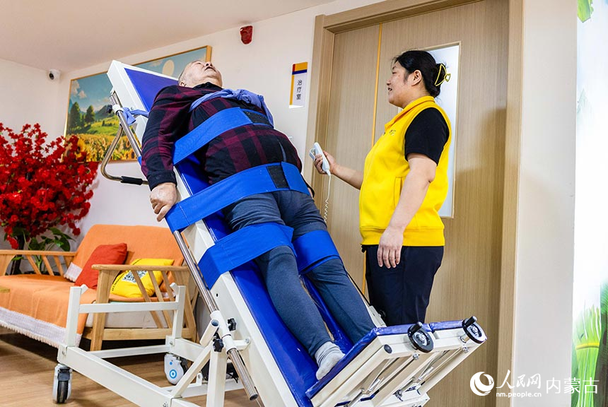 工作人員在呼和浩特市玉泉區居家社區養老服務標准化示范中心指導老人進行康復訓練。丁根厚攝