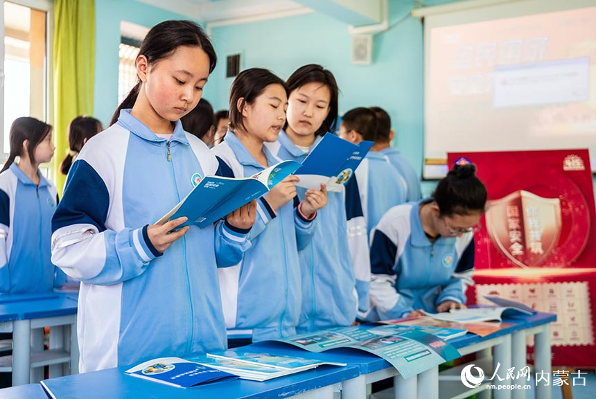呼和浩特市第二十七中学学生在国家安全教育主题活动现场阅读宣传资料。丁根厚摄