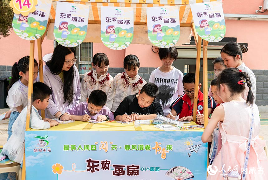 呼和浩特市玉泉区南茶坊小学学生在世界读书日系列主题活动现场参加“东坡画扇”活动项目。丁根厚摄