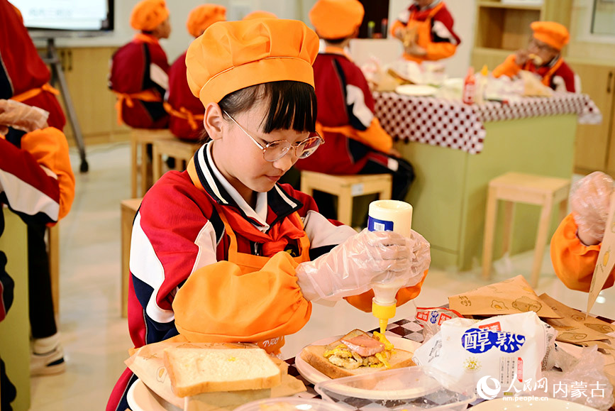 伊金霍洛旗第五小学学生在烹饪社团课上制作三明治。人民网记者 寇雅楠摄