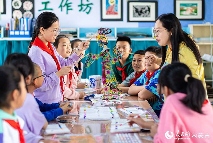 4月22日，呼和浩特市玉泉区小召小学老师在指导学生做皮影道具。丁根厚摄