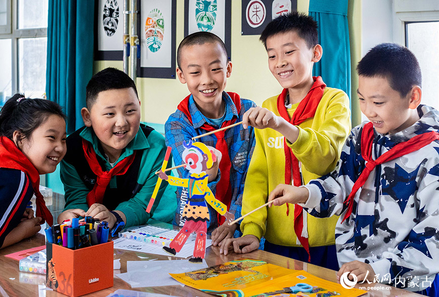 4月22日，呼和浩特市玉泉区小召小学学生在体验操控皮影戏道具。丁根厚摄