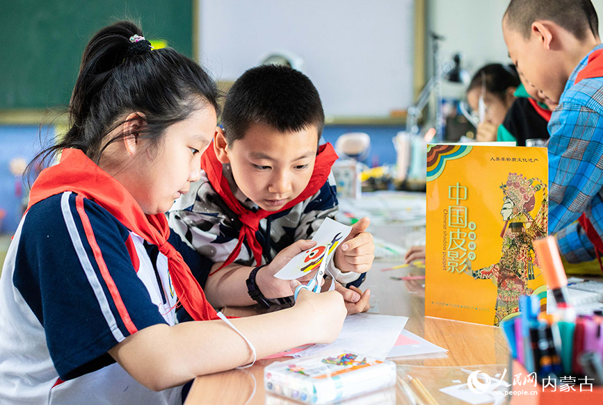 4月22日，呼和浩特市玉泉区小召小学学生在皮影技艺课上学习制作表演道具。丁根厚摄
