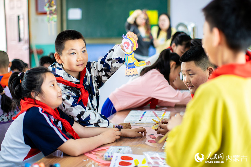 4月22日，呼和浩特市玉泉区小召小学学生在制作皮影戏表演道具。丁根厚摄