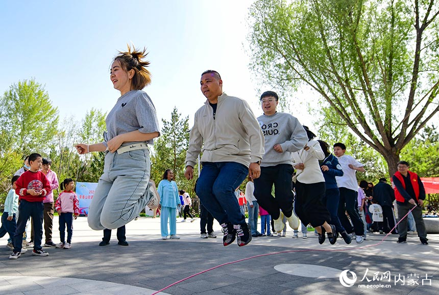 鄂尔多斯市康巴什区学府社区居民在“集体跳绳”趣味运动项目比赛中。王正摄