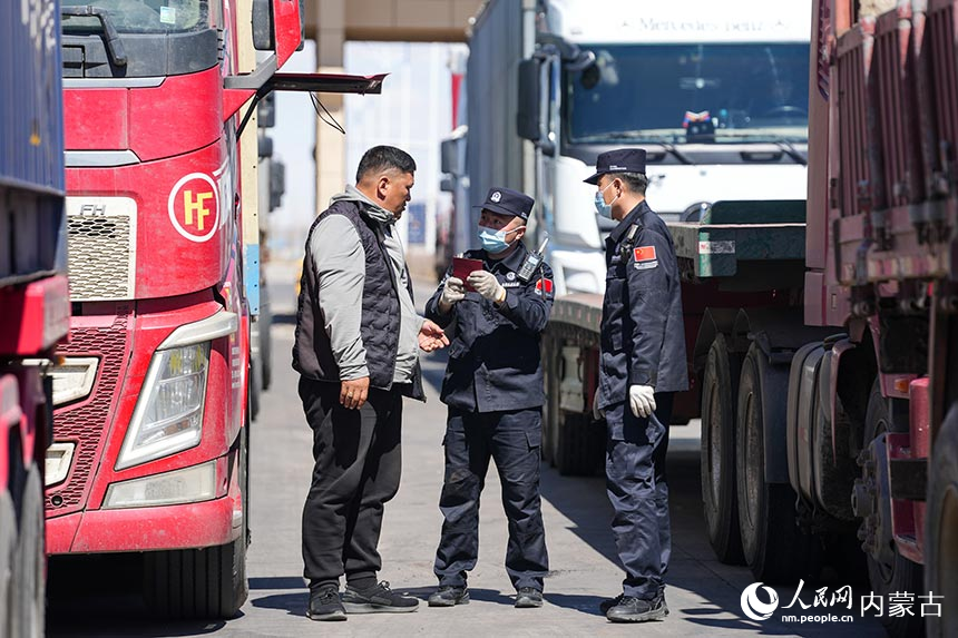 二连出入境边防检查站移民管理警察为货车司机办理通关手续。郭鹏杰摄