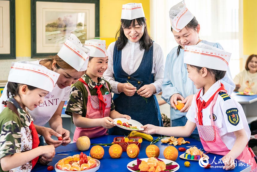 呼和浩特市玉泉区五塔寺东街小学学生和妈妈一起制作水果拼盘。丁根厚摄