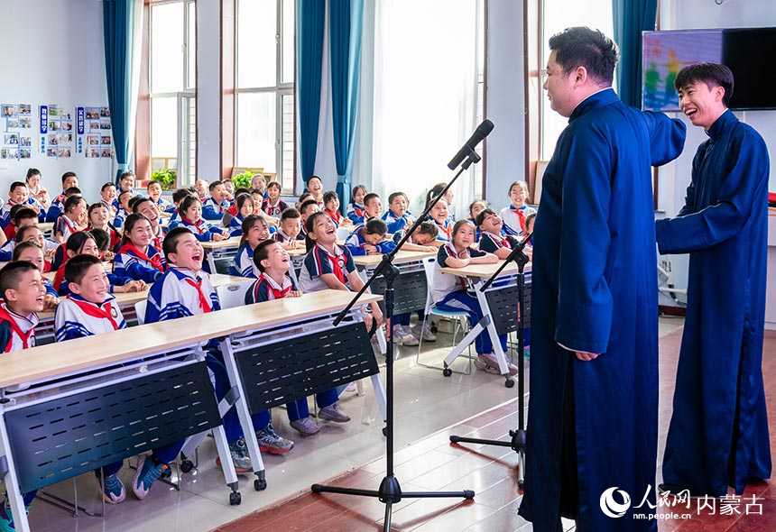 内蒙古大盛魁相声馆的演员在为呼和浩特市玉泉区小召小学学生表演相声《文明礼仪》。丁根厚摄