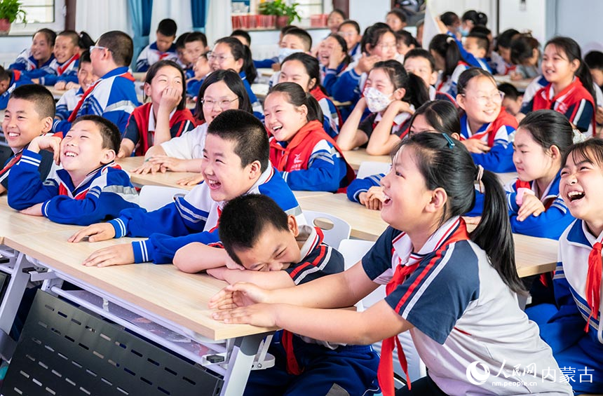 呼和浩特市玉泉区小召小学学生在观看相声表演时开心地笑着。丁根厚摄