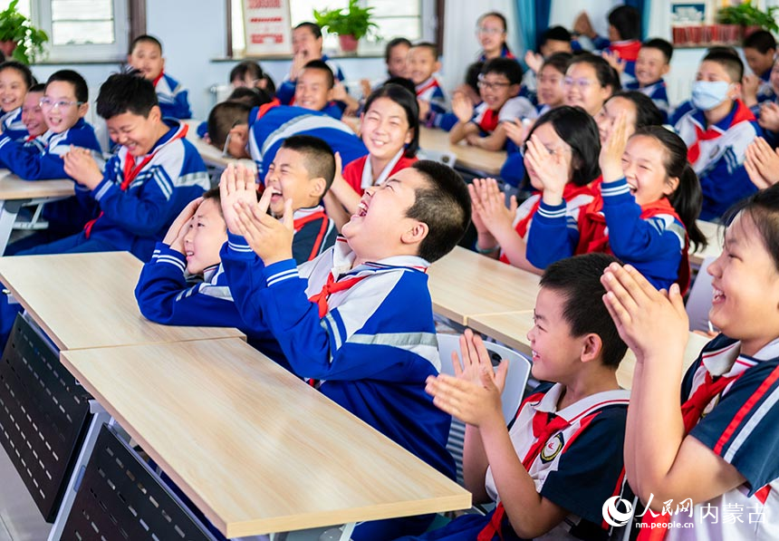 呼和浩特市玉泉区小召小学学生在观看相声表演时开心地笑着。丁根厚摄