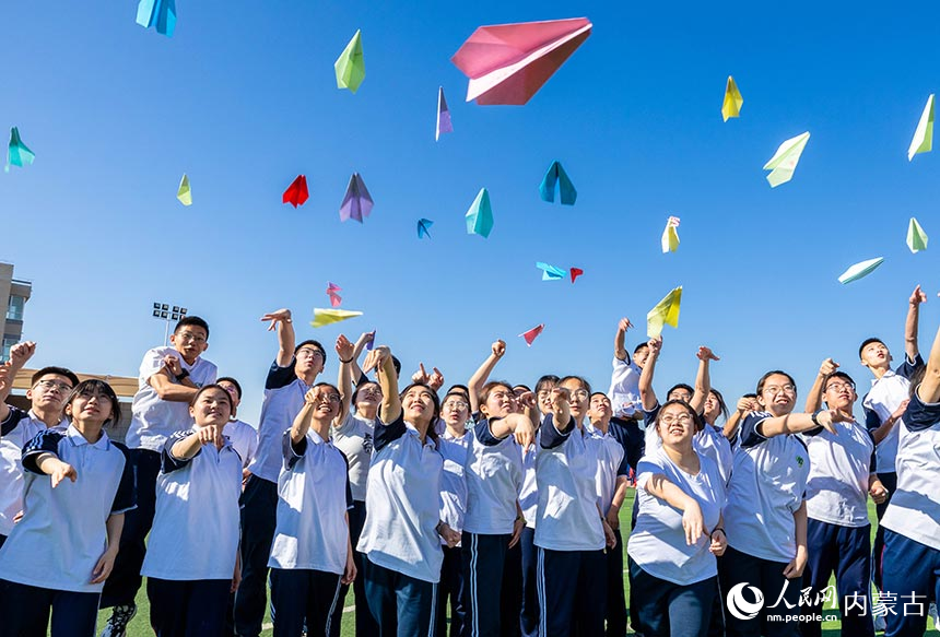 呼和浩特市第十二中學高三學生在操場上放飛寫有自己心願的紙飛機。丁根厚攝