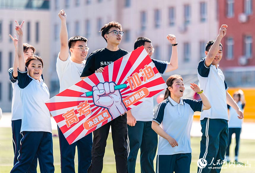 呼和浩特市第十二中學高三學生手持“高考加油”字樣在趣味游戲活動上歡呼。丁根厚攝