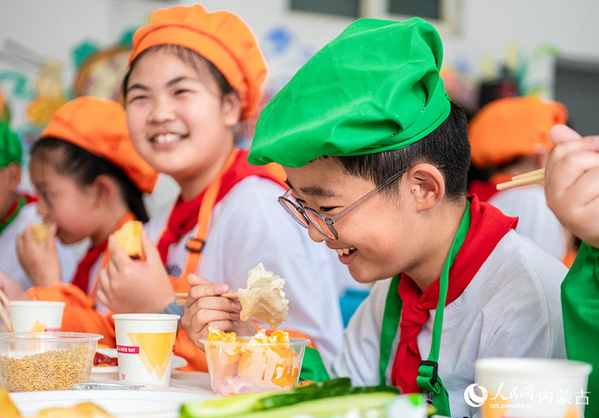 5月24日，呼和浩特市玉泉区南柴火市街小学学生在“烹饪课堂”上品尝烧卖。丁根厚摄