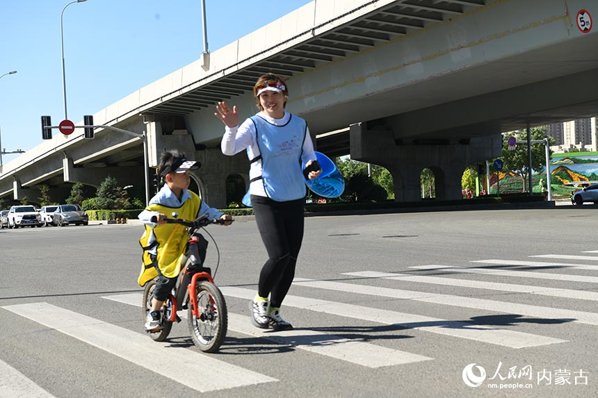 参加活动的跑友招手致意。人民网记者 张雪冬摄