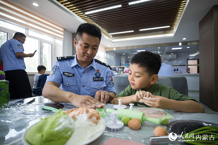 二连出入境边防检查站民警和孩子们一起动手制作面点。郭鹏杰摄