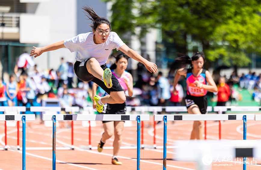 5月26日，参赛选手在呼和浩特市中学生田径运动会女子初中组五项全能100米栏比赛中。丁根厚摄