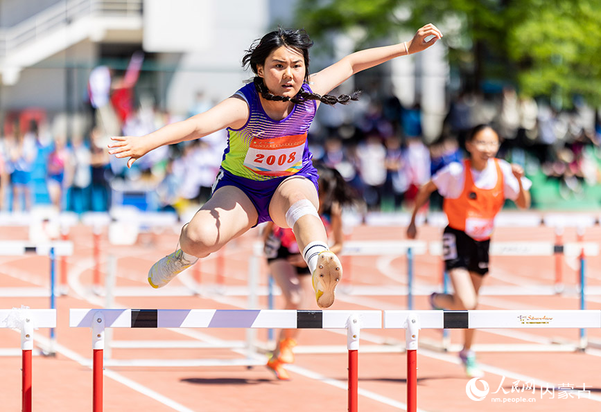 5月26日，参赛选手在呼和浩特市中学生田径运动会女子初中组五项全能100米栏比赛中。丁根厚摄