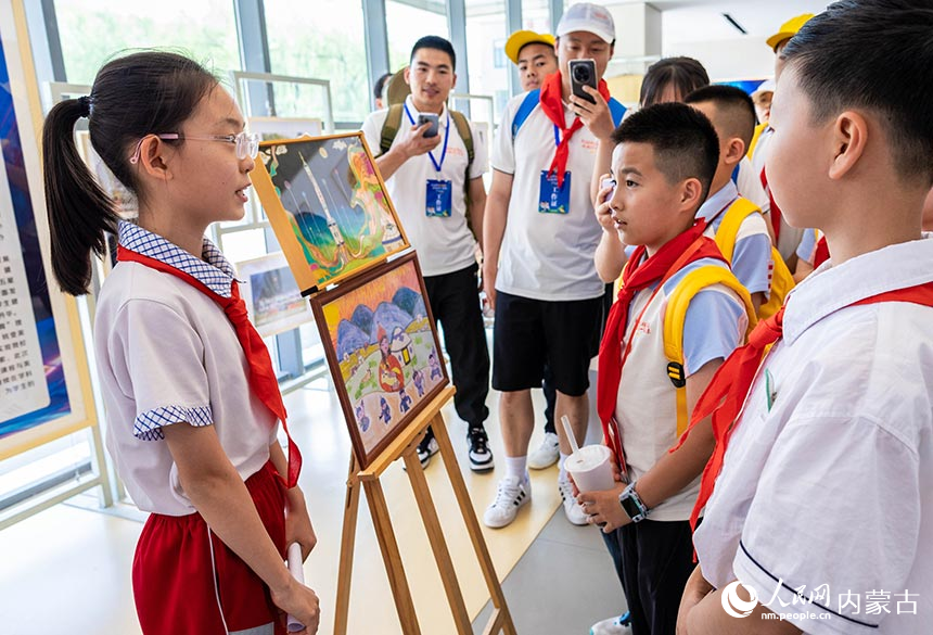 内蒙古呼和浩特市锡林南路小学学生在为各族少年儿童代表分享绘制天宫画作的心得。丁根厚摄