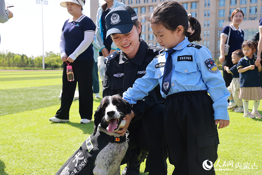 小朋友在训导员的陪同下与警犬互动。周煦坪摄