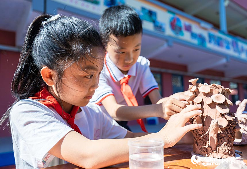 呼和浩特市玉泉区西菜园小学学生在庆“六一”主题活动现场展示泥塑制作技艺。丁根厚摄