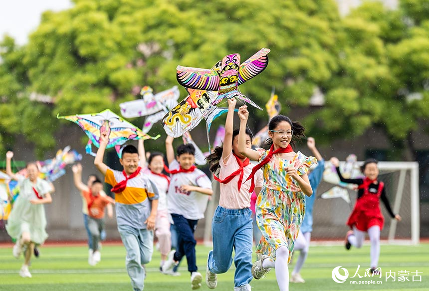 呼和浩特市玉泉区五塔寺东街小学学生在“我们的节日·端午”主题活动上放飞纸鸢。丁根厚摄