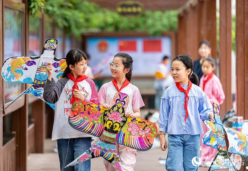 呼和浩特市玉泉区五塔寺东街小学学生在“我们的节日·端午”主题活动上准备放飞刚刚绘制的纸鸢。丁根厚摄