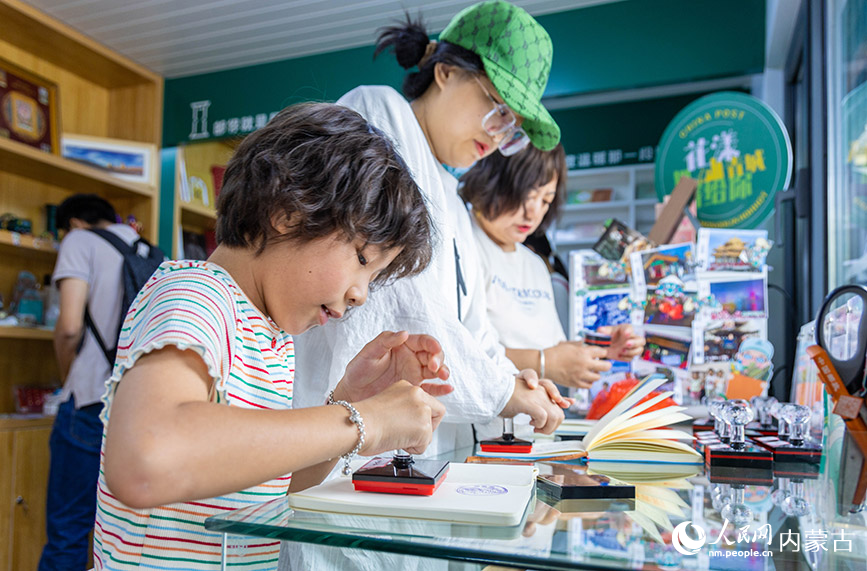 6月18日，游客在呼和浩特市玉泉区塞上老街旅游休闲街区“塞上主题邮局”内集章打卡，珍藏“独家记忆”。丁根厚摄