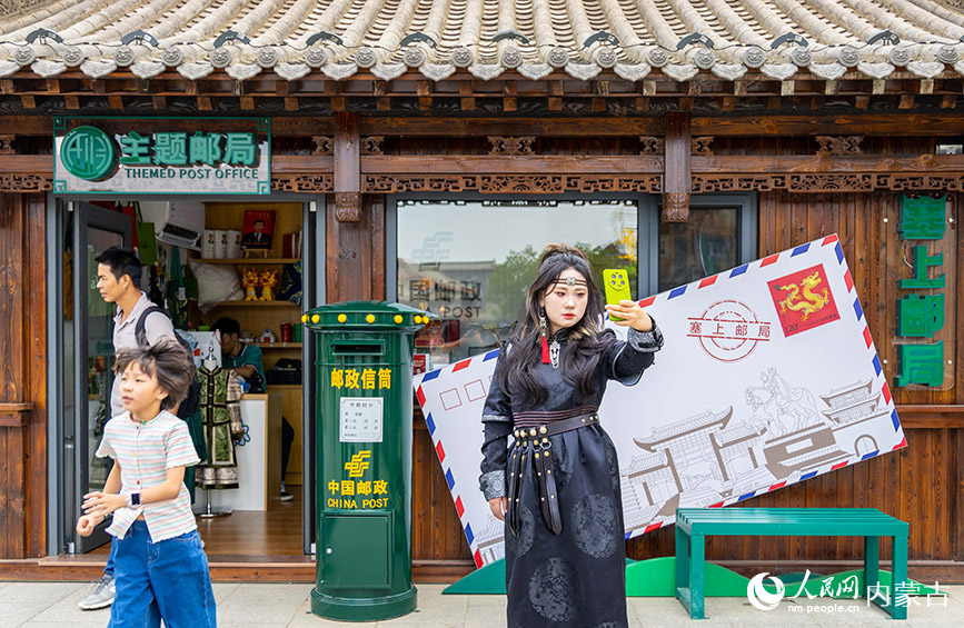 6月18日，游客在呼和浩特市玉泉区塞上老街旅游休闲街区“塞上主题邮局”前留影。丁根厚摄