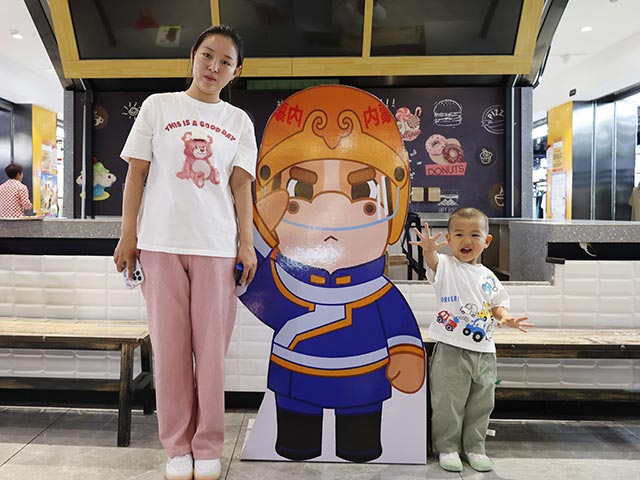 扎赉特旗万泰商场群众们纷纷与兴安消防IP形象“消兴兴”合影