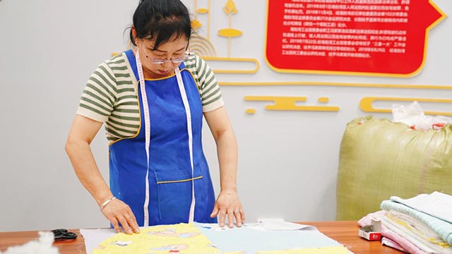 缝纫小队的居民正在裁剪布料
