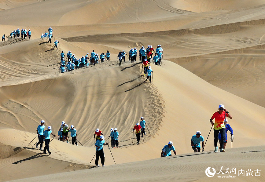 6月25日，运动爱好者在沙漠越野杖走公开赛比赛中（无人机照片）。王正摄