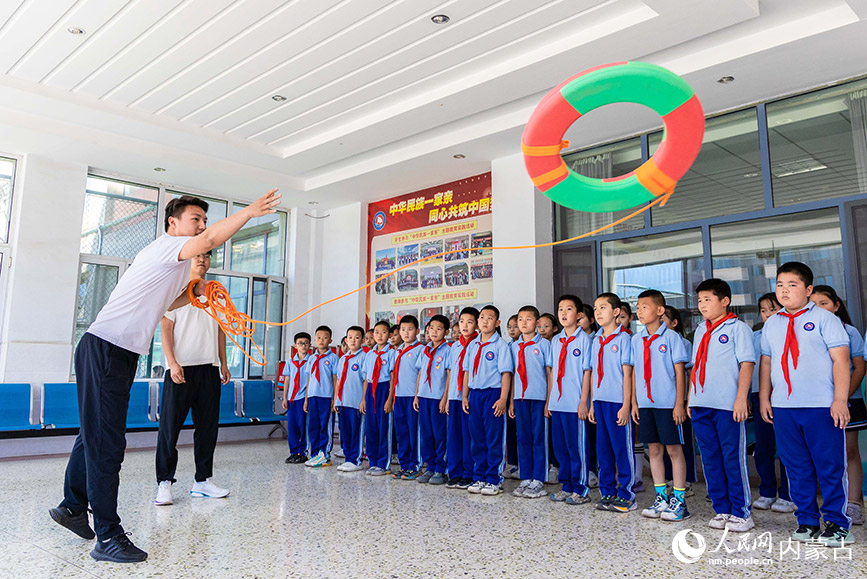 6月25日，游泳救生协会志愿者指导小学生演练溺水自救互救的基本技能。丁根厚摄