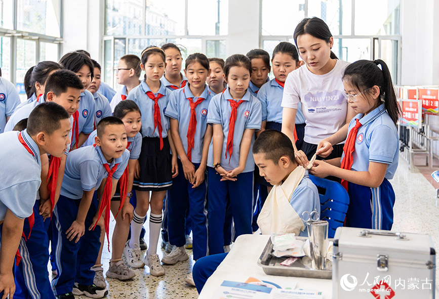 6月25日，呼和浩特市玉泉区通顺街小学老师在给学生们讲解创伤包扎知识。丁根厚摄