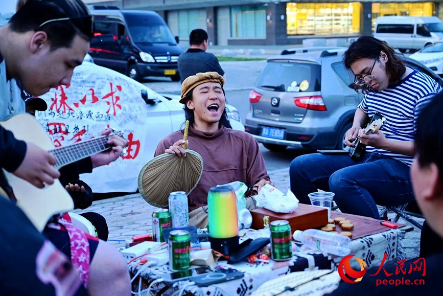 叶镇豪（左二）与满洲里当地的年轻人在街头高歌。人民网记者 寇雅楠摄