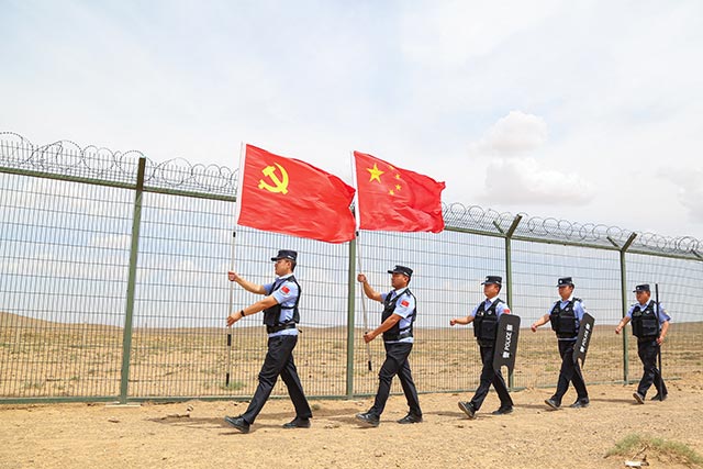 6月29日，内蒙古满都拉边境派出所民警擎旗巡边，迎接党的生日（张宇摄）