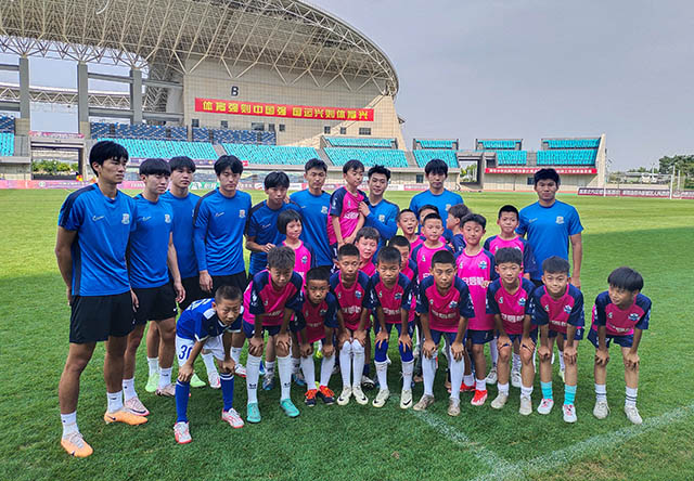 U21球员 与小球员合影。实习生 王艺蓉摄