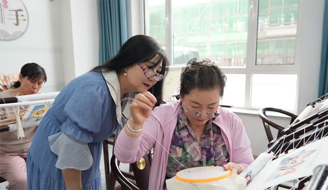 苏晓玲正在为学员教授羢绣技艺。