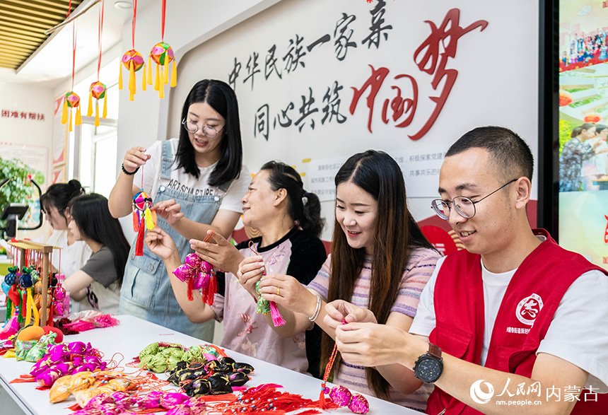 呼和浩特市玉泉区清泉街社区居民和志愿者在“我们的节日·七夕”主题活动现场体验制作香囊。丁根厚摄