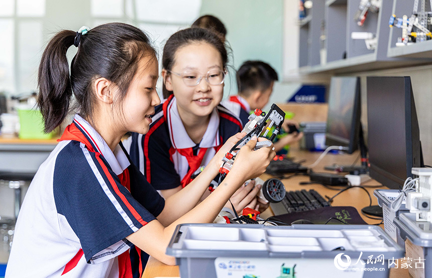 呼和浩特市玉泉区石东路小学学生们在人工智能科普课堂上组装调试编程机器人。丁根厚摄