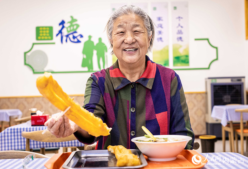 老人在呼和浩特市玉泉区康居社区“为老餐厅”内吃早餐。丁根厚摄