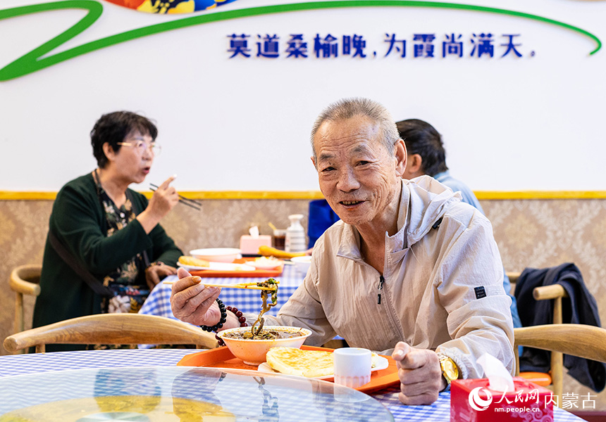 老人在呼和浩特市玉泉区康居社区“为老餐厅”内吃早餐。丁根厚摄