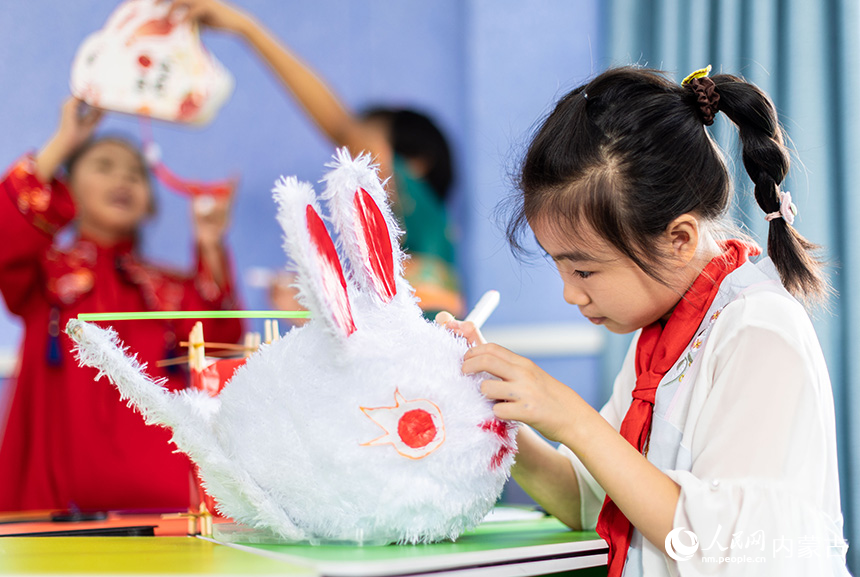 呼和浩特市玉泉区恒昌店巷小学学生在绘制玉兔花灯。丁根厚摄