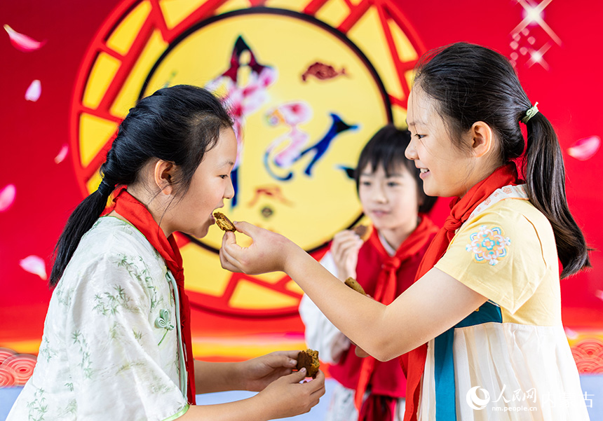 呼和浩特市玉泉区恒昌店巷小学学生在品尝自制的手工月饼。丁根厚摄