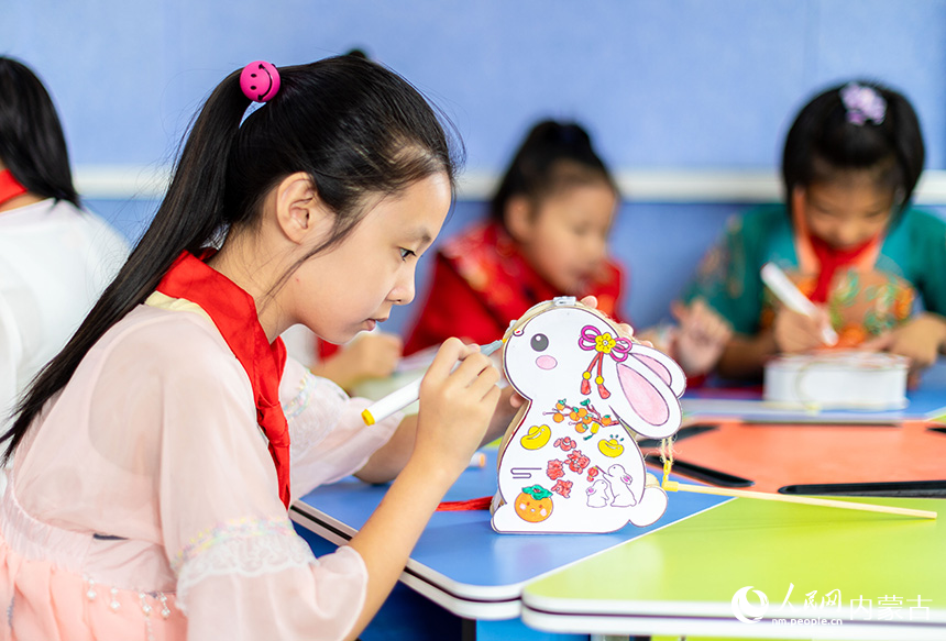 呼和浩特市玉泉区恒昌店巷小学学生在绘制玉兔花灯。丁根厚摄