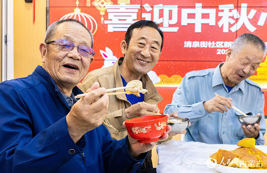 内蒙古呼和浩特市玉泉区清泉街社区居民在开心地品尝饺子。丁根厚摄