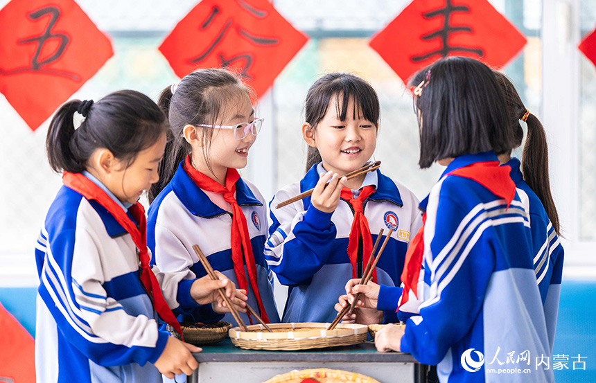 呼和浩特市玉泉区通顺街小学学生在参加夹豆子比赛。丁根厚摄