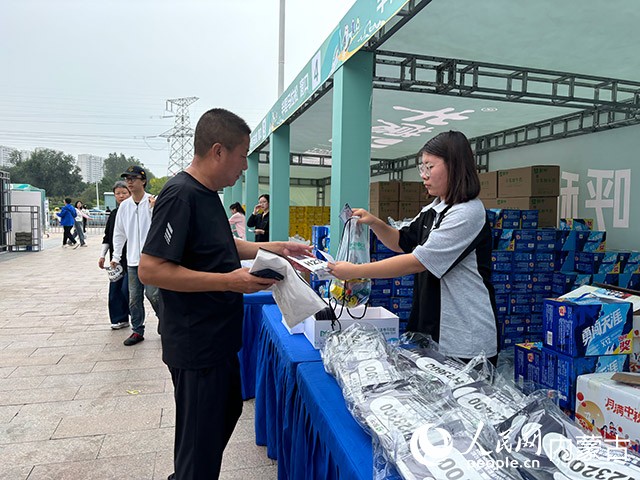 跑友现场领取参赛物资。人民网记者 齐浩男摄
