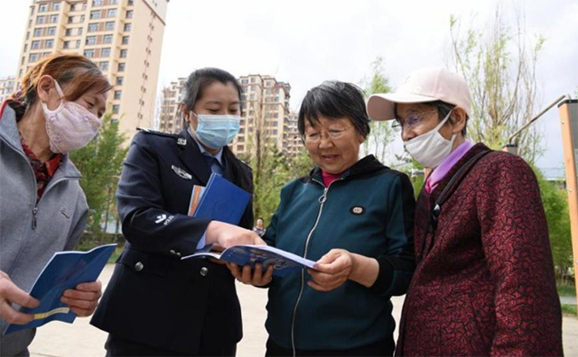 集寧區新體路派出所民警走進轄區群眾發放反詐騙宣傳手冊。唐璇博 攝