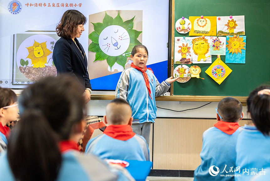 呼和浩特市玉泉区清泉街小学学生在和伙伴们分享手工作品的创作思路。丁根厚摄