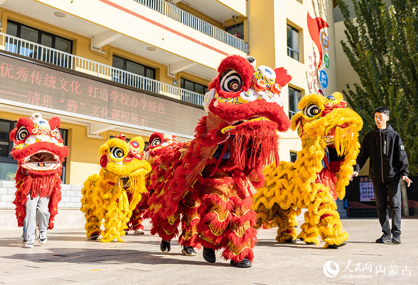 呼和浩特市玉泉區清泉街小學學生在專業老師的指導下練習舞獅步伐。丁根厚攝